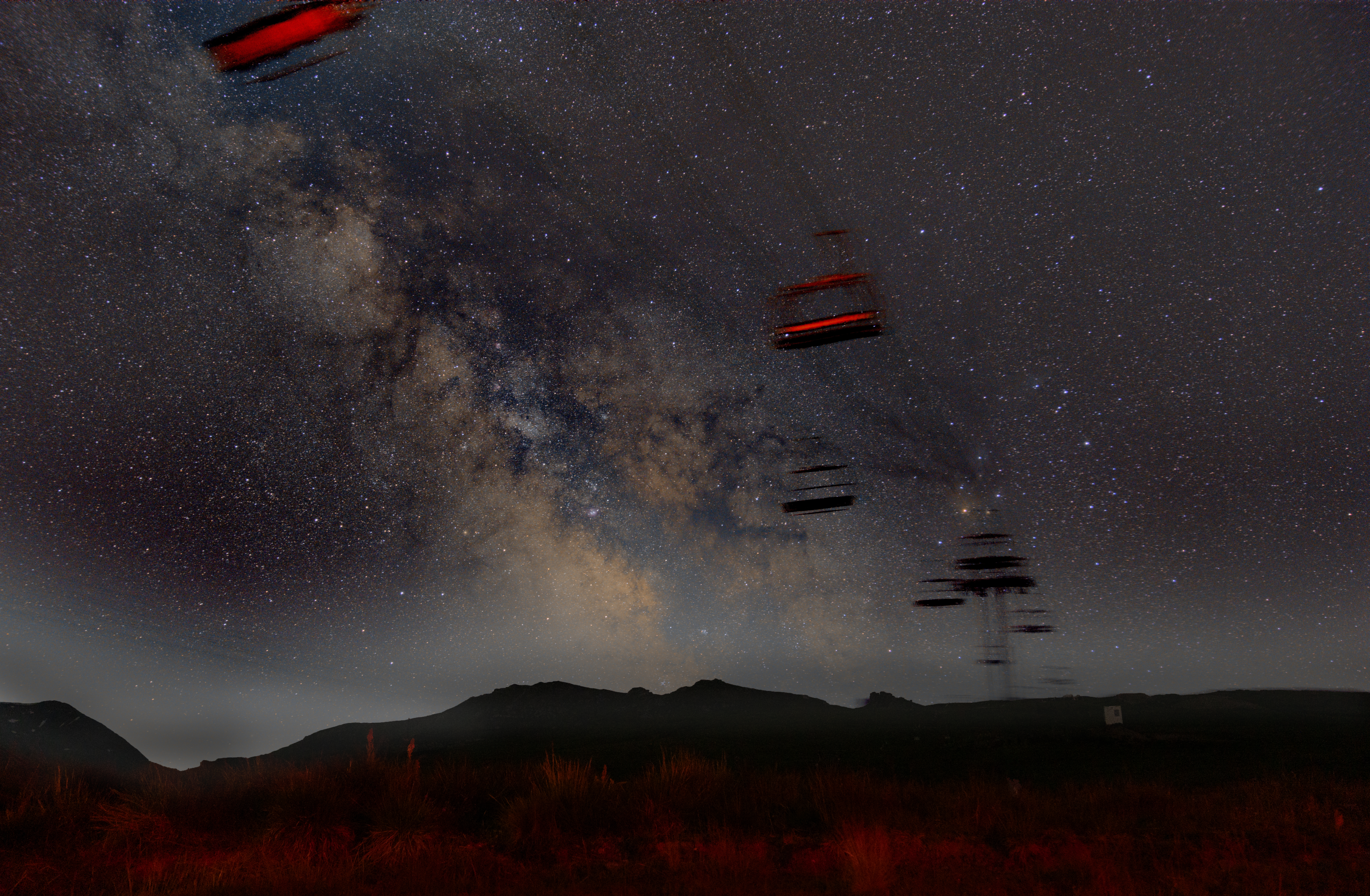 Milky Way arching over a mountain landscape at night, long-exposure astrophotography
