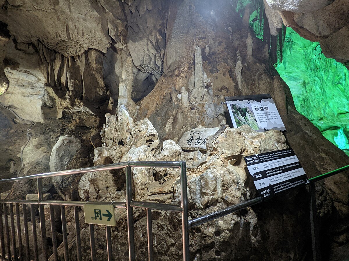Wide cave chamber with dramatic stalactite formations and colored lighting in Abukuma Cave