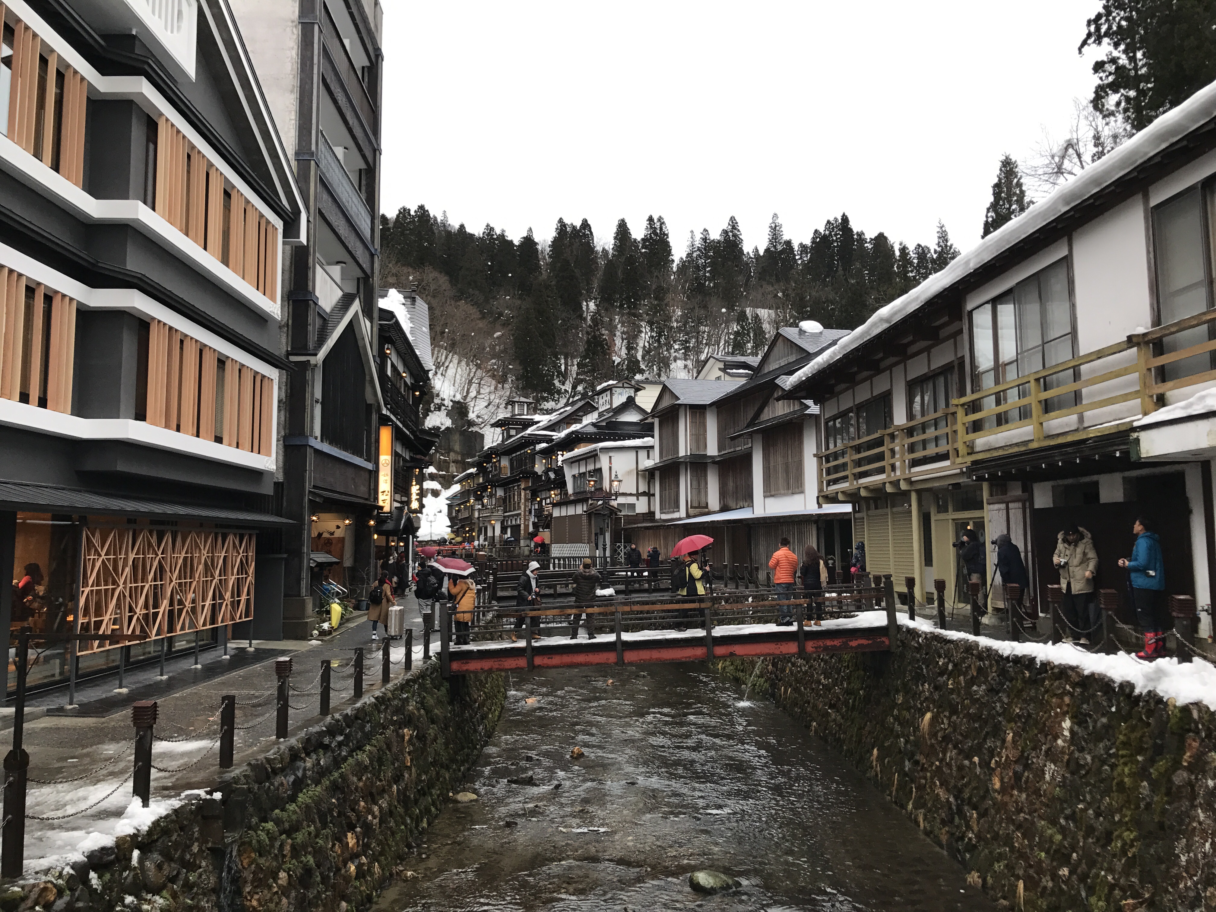 The narrow river street of Ginzan Onsen with traditional wooden ryokan on both sides in Yamagata