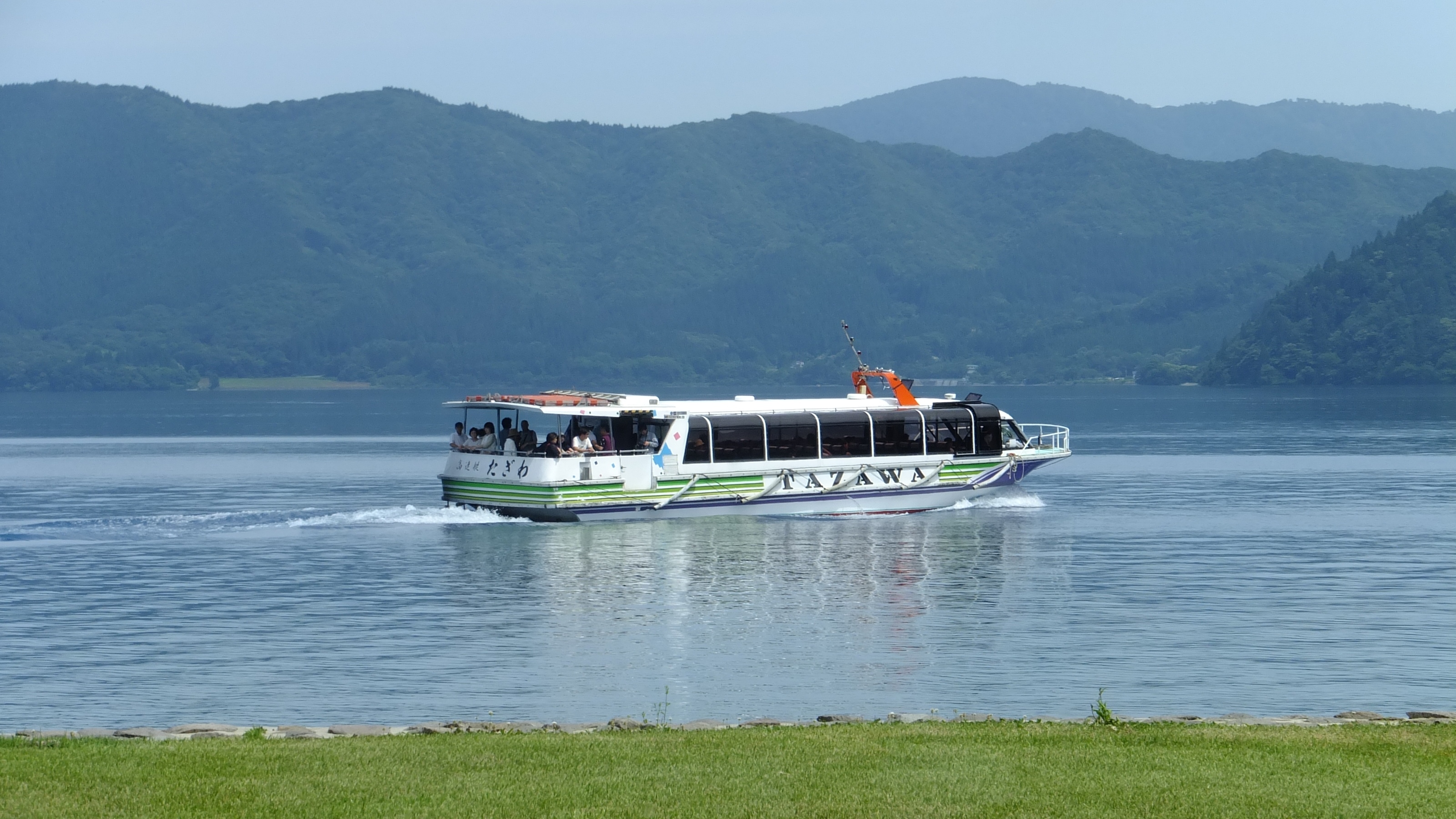 Cruise boat on the brilliant blue waters of Lake Tazawa, Akita, Japan