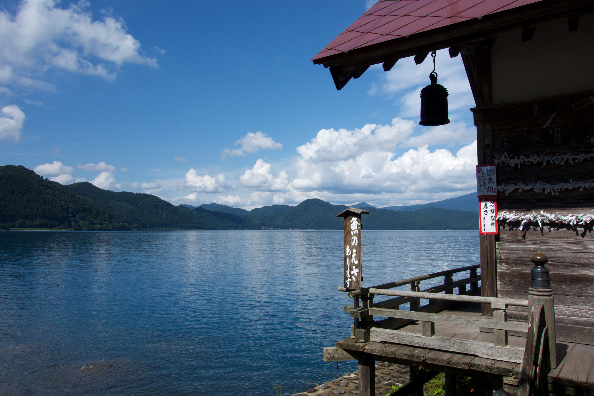 Wide panoramic view of Lake Tazawa showing its deep blue color from the shoreline
