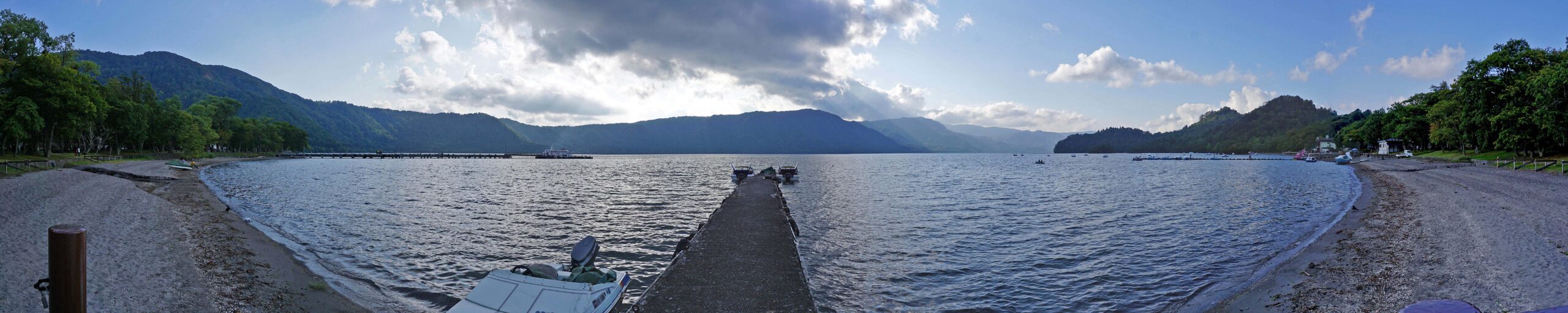 Aerial view of Lake Towada surrounded by dense forest