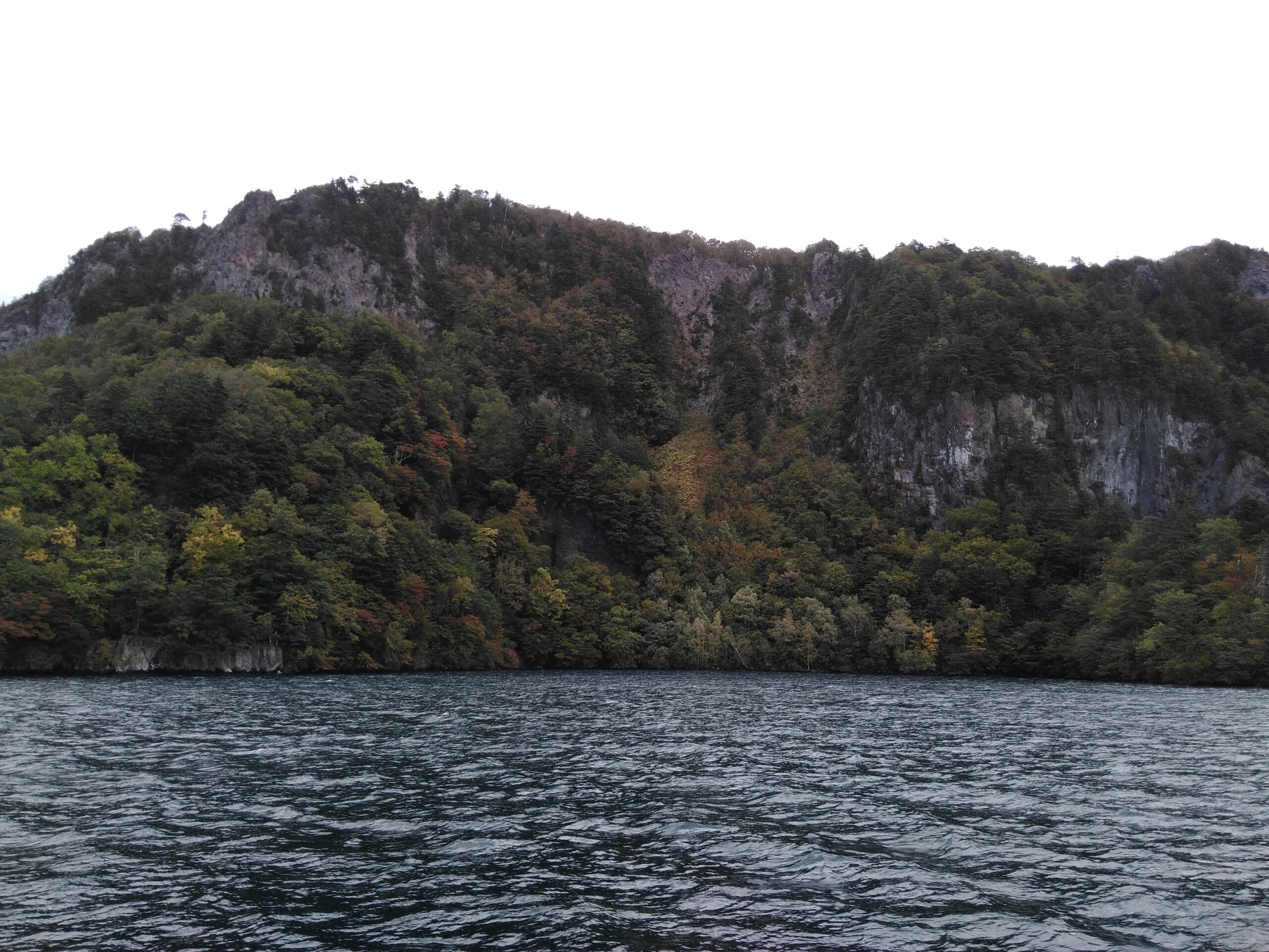 Lake Towada surrounded by vibrant autumn foliage