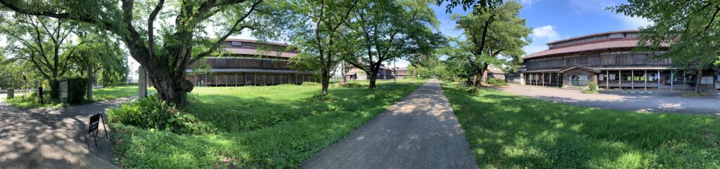 Panoramic view of the Matsugaoka Kaikon silkworm rearing barns at Tsuruoka with the surrounding rice fields and mountains