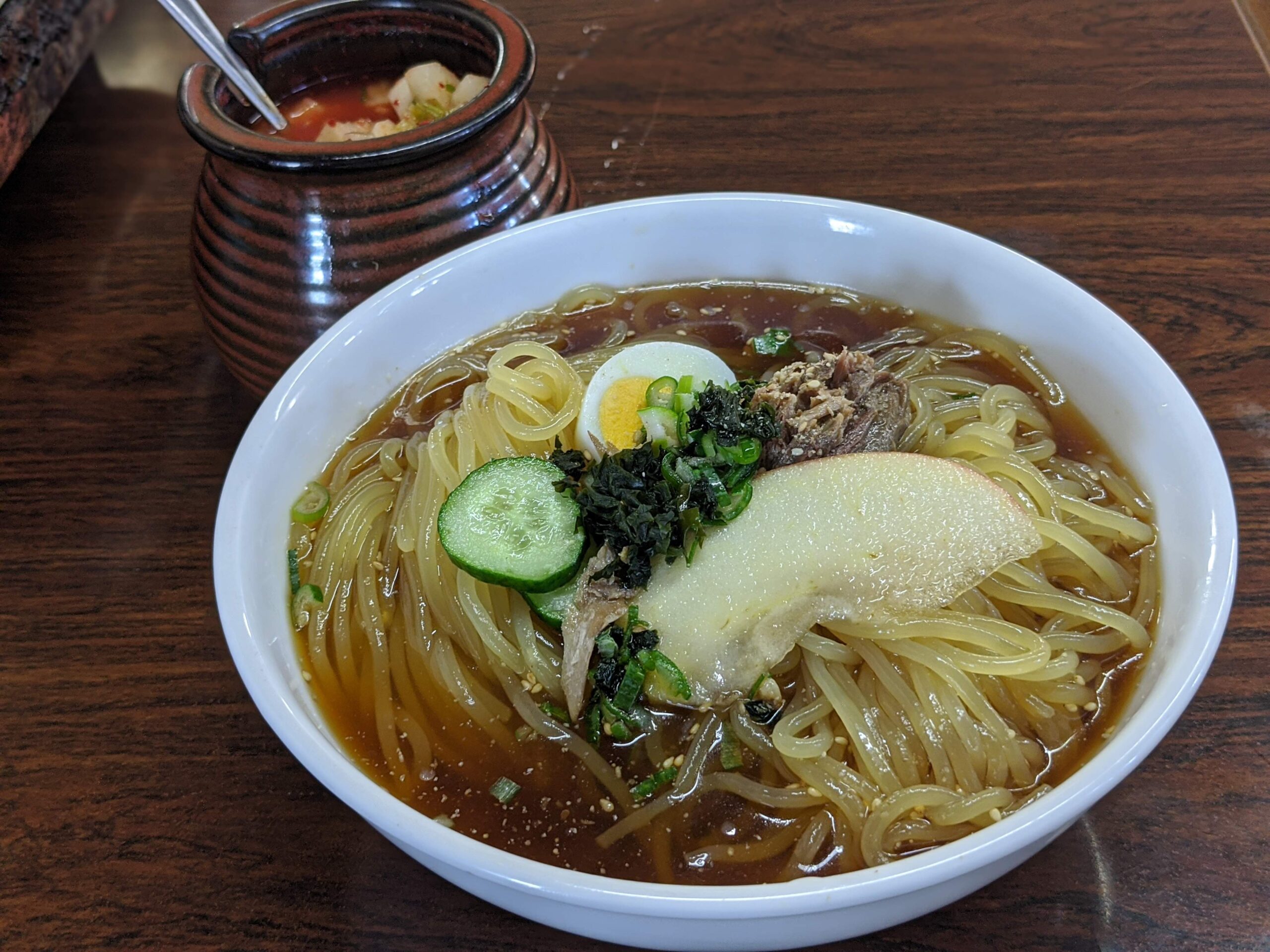 Bowl of Morioka reimen cold noodles with watermelon slice