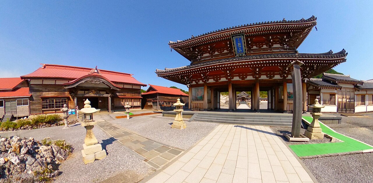 The main hall of Bodaiji Temple at Osorezan with volcanic steam rising in the background