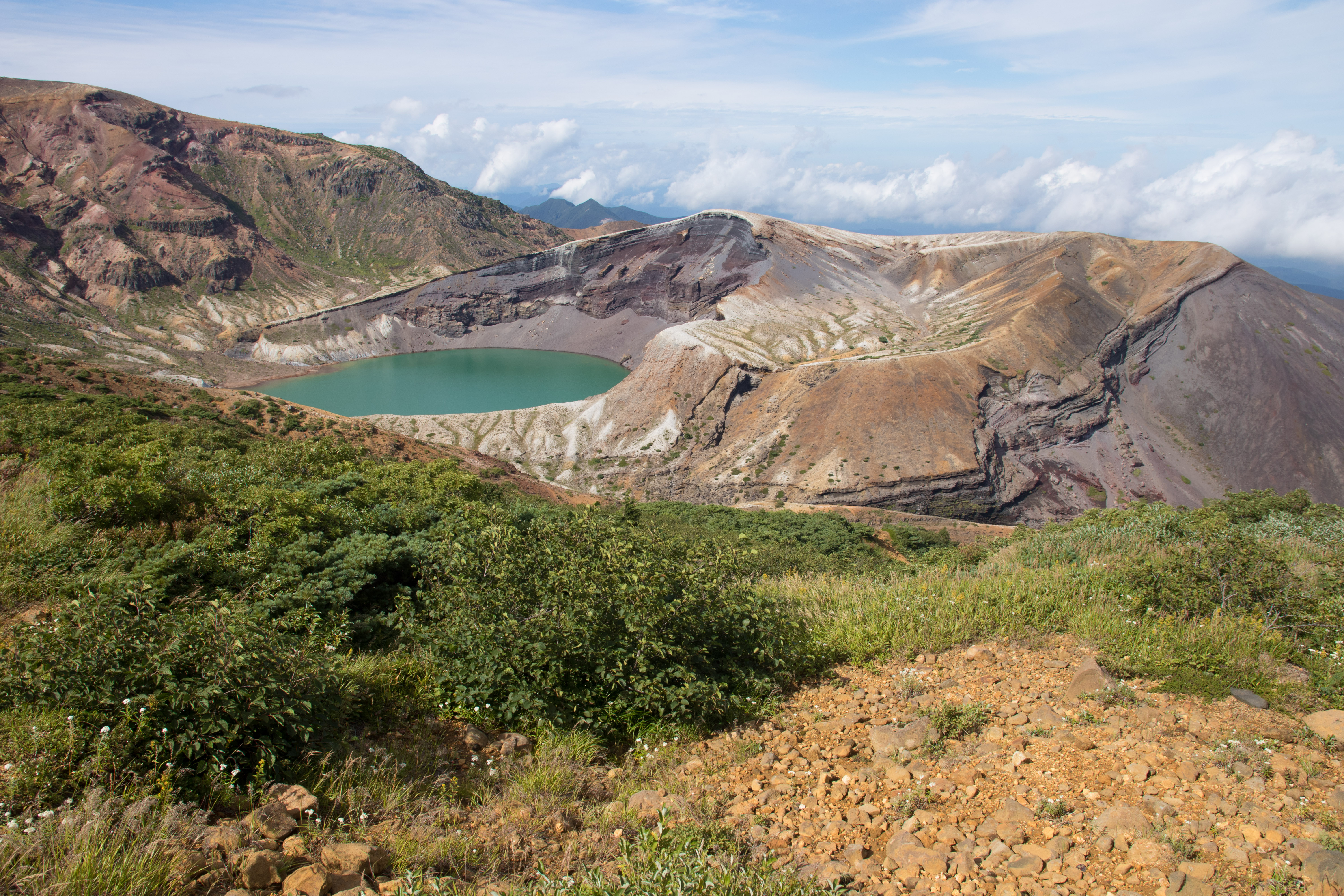 Zao Okama crater lake from above showing the vivid emerald-green water inside the volcanic crater