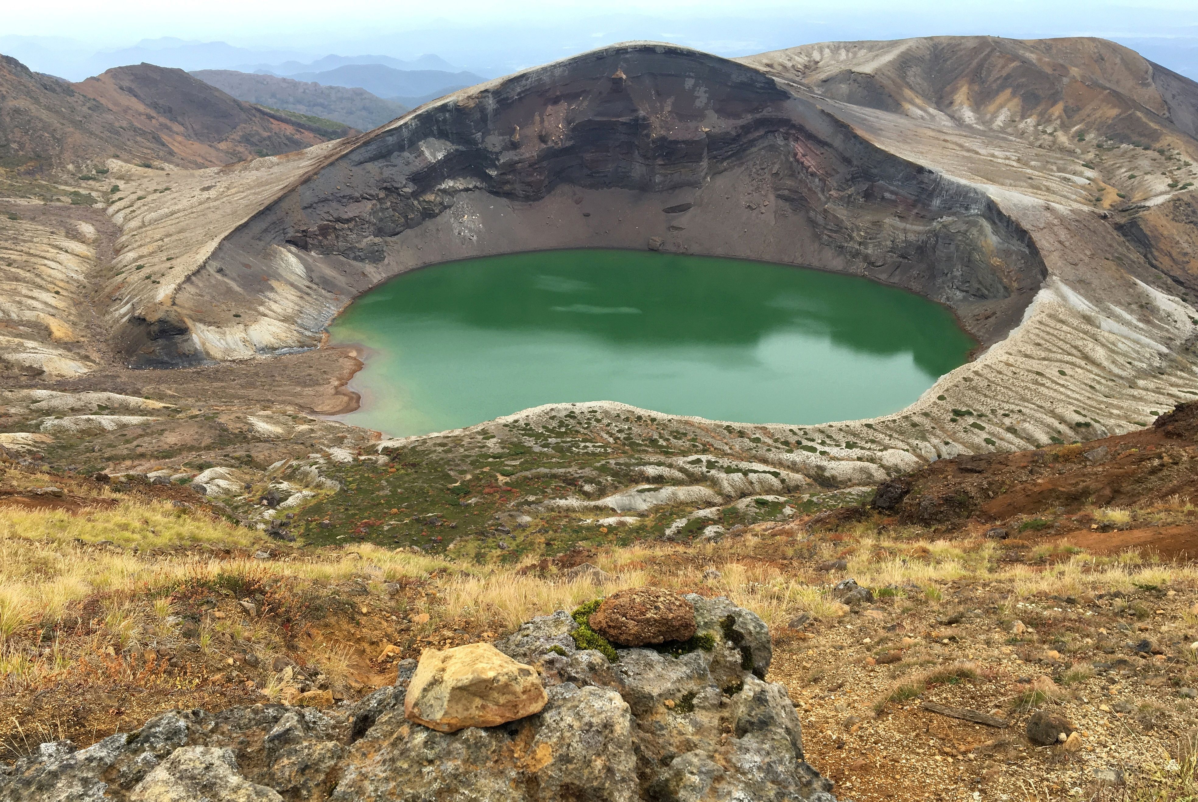Zao Okama crater lake facing north showing the volcanic landscape and surrounding mountains