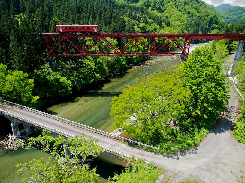 Akita Nairiku Line train crossing a scenic bridge in Akita Prefecture