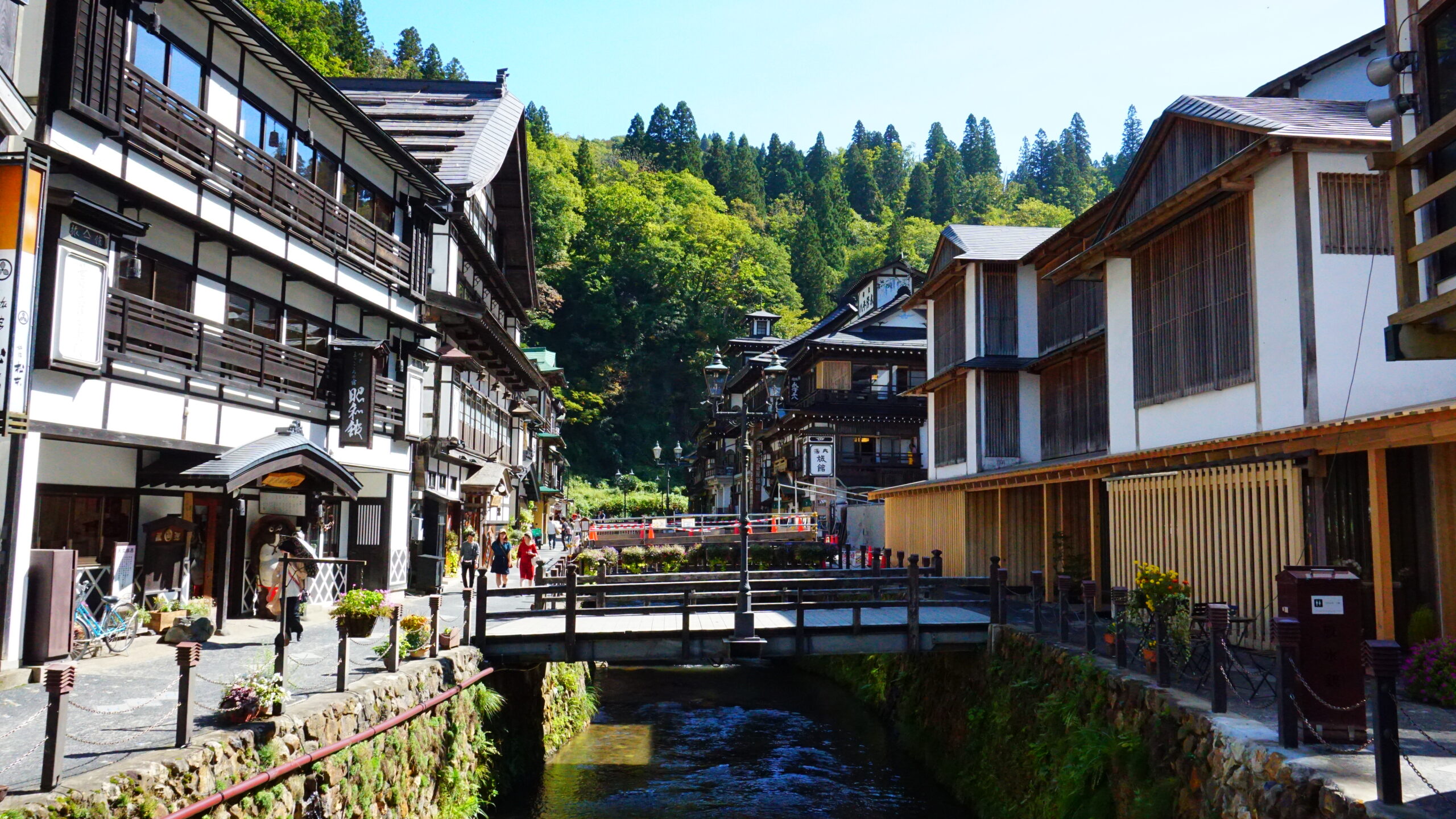 Ginzan Onsen in autumn with colorful maple leaves surrounding the traditional buildings