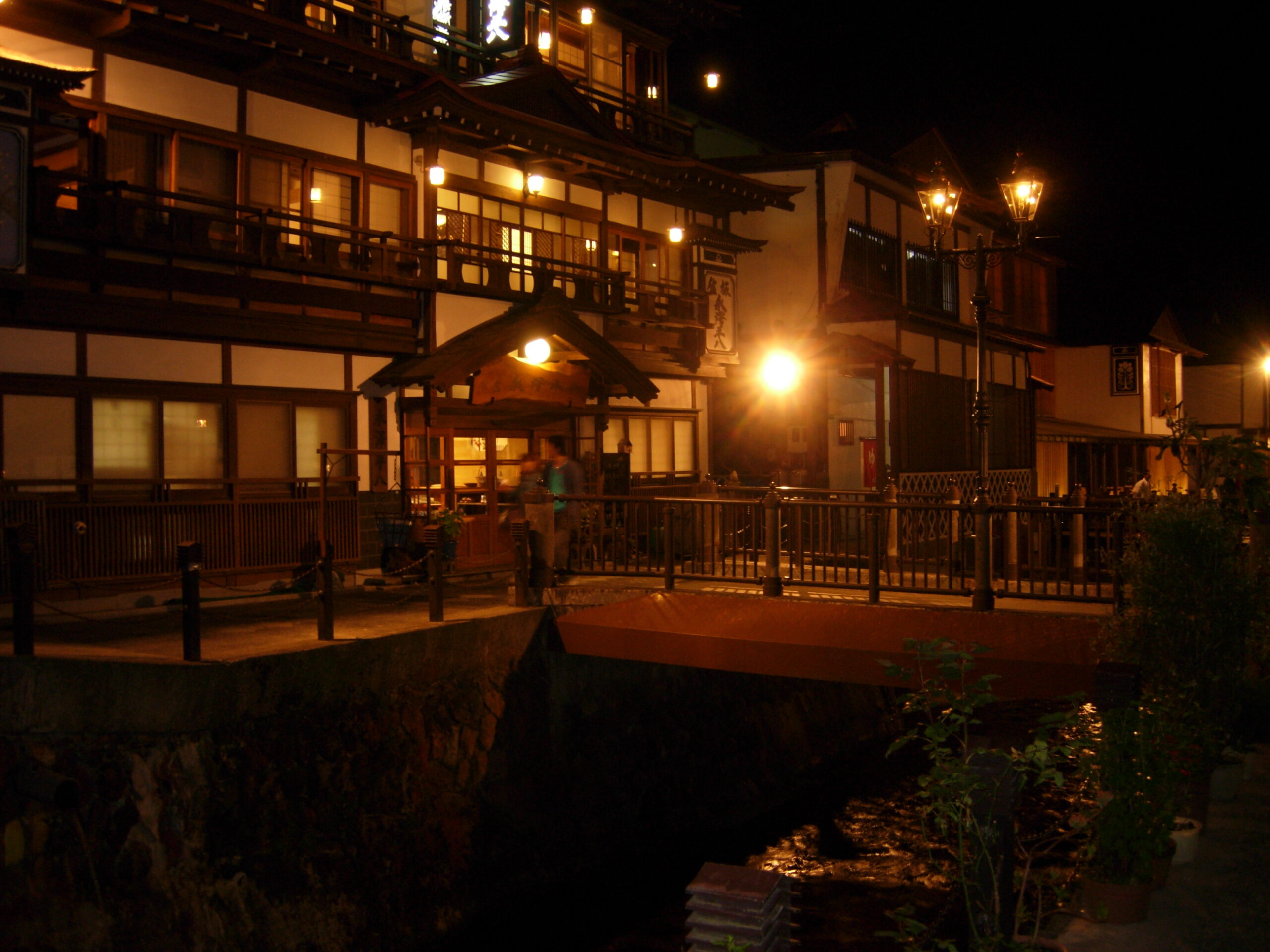 Street view of Ginzan Onsen showing traditional Taisho-era wooden buildings along the river