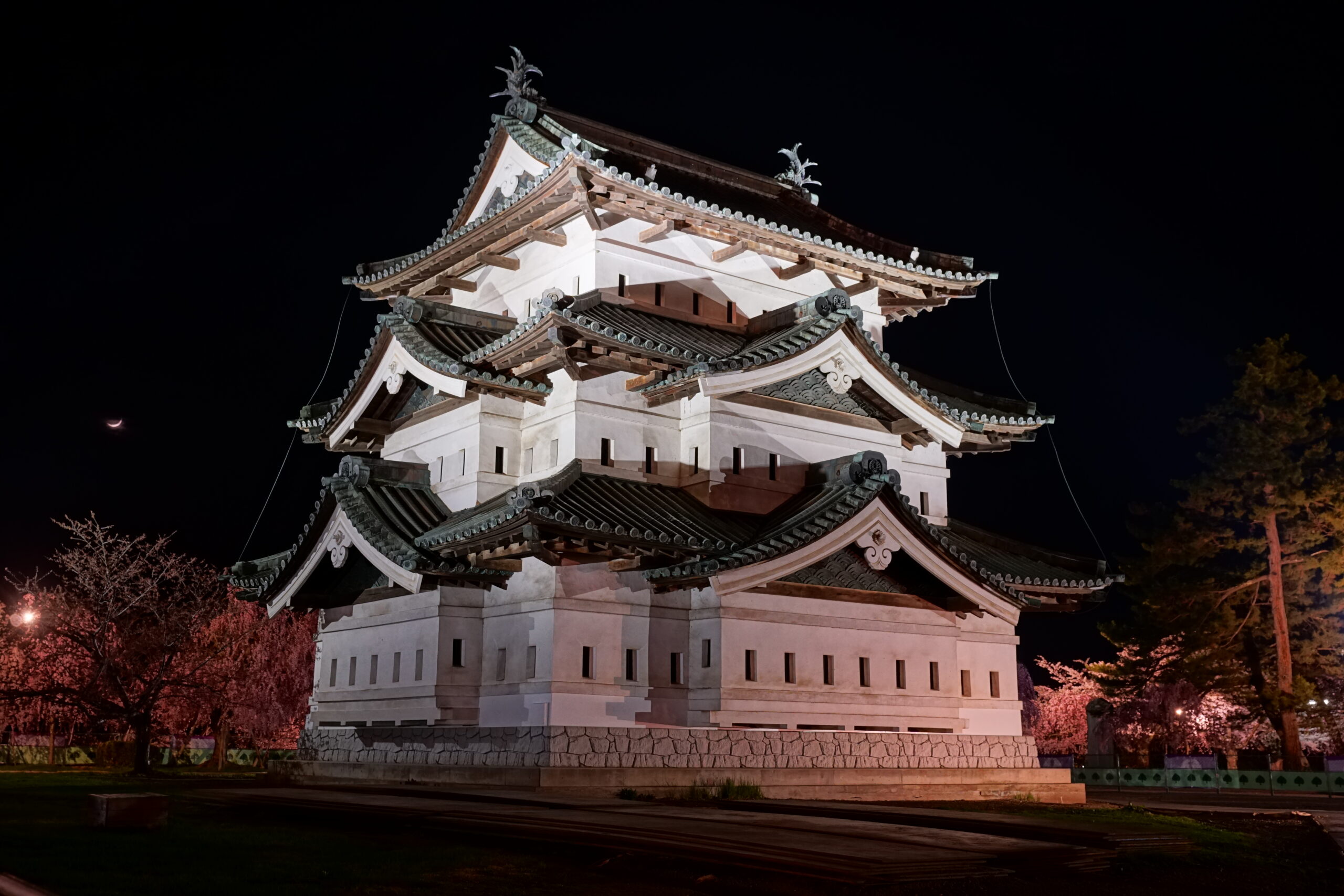 Hirosaki Castle illuminated at night reflecting in the moat