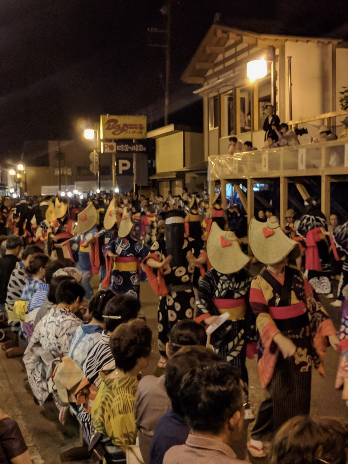 Nishimonai Bon Odori performers in traditional kimono and amigasa hats dancing in procession