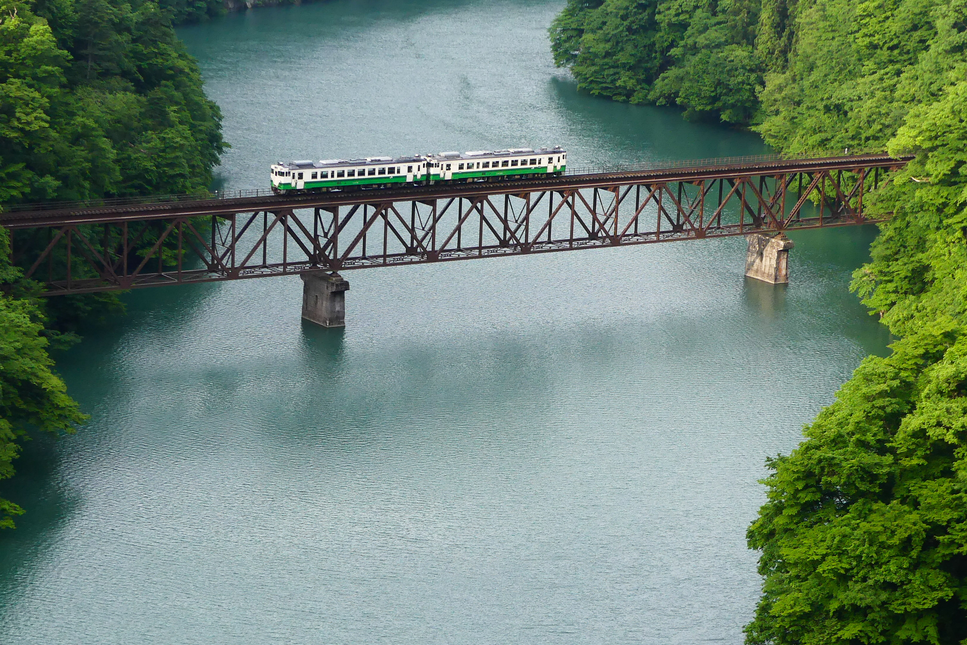The Tadami Line third bridge crossing in summer surrounded by green forests