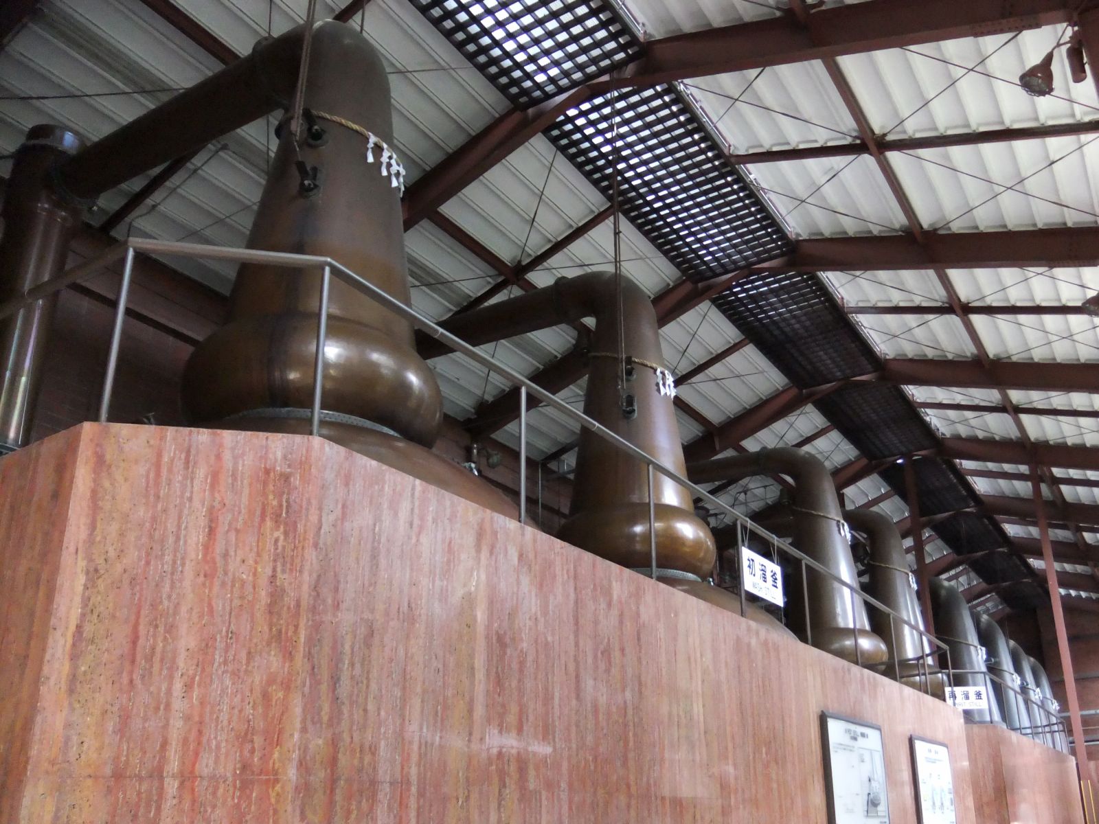 Traditional stone and wood buildings at Miyagikyo Distillery with mountain backdrop